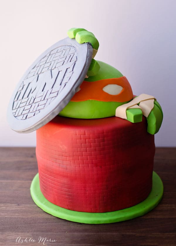 Teenage Mutant ninja turtle cake - climbing out of a sewer with a TMNT manhole cover